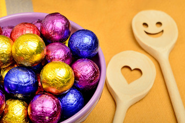 Bowl with colorful chocolate and lovely wooden spoon