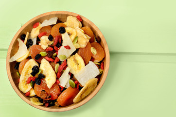 Bamboo bowl with dried fruits on table
