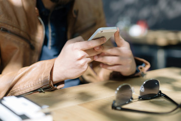 Online world. Hipster using modern smartphone in contemporary ca