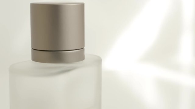 Luxurious parfum bottle slow tilting on white background 4K 3840X2160 UltraHD video - Slow tilt on fragrance spray bottle 4K 2160p UHD footage 