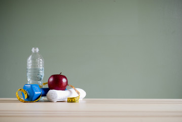 dumbbell and apple on desk
