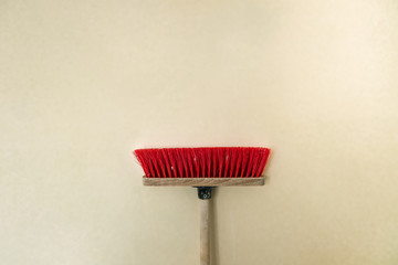 red mop against a beige wall