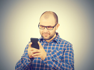 Caucasian man typing a message on mobile phone.