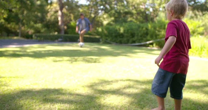 Modern Dad and Little Boy Playing Ball, Barefoot, in Garden