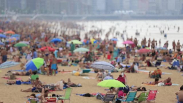 Time lapse of people relaxing on crowded beach at Gijon, north Spain