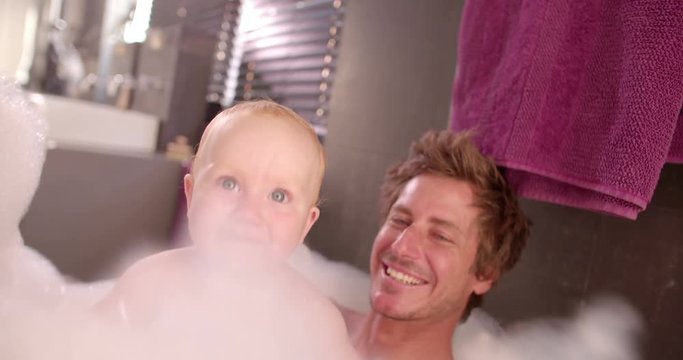 Modern Dad Taking Bubble Bath with Infant Daughter