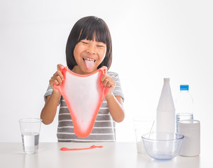 cute little asian girl making science experiment of slime on isolate white background