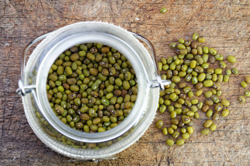 Mung bean in glass jar on wooden table. Selective focus to emphasize.