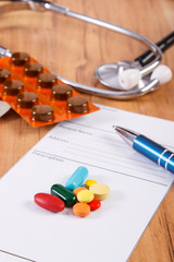 Medical pills, tablets or supplements with prescription and stethoscope, health care concept