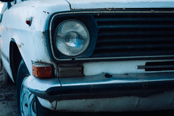 old abandoned white car, shot by hands