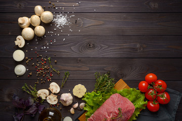 raw meat with ingredients on a wooden background