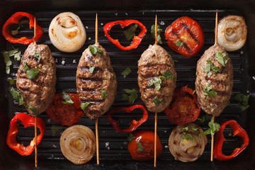Kofta kebab with grilled vegetables on grill close-up. horizontal top view

