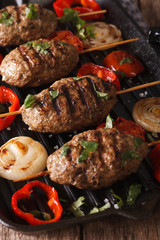 Kyufta kebab with grilled vegetables closeup on a grill pan. Vertical
