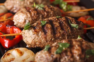 Plexiglas foto achterwand Turkish kebab with vegetables macro on a grill pan. horizontal © FomaA