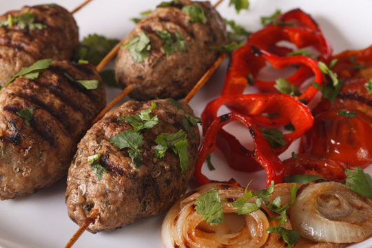 Turkish kofte kebab with grilled vegetables close-up. horizontal
