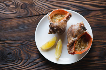 Rapana shells with julienne on a rustic wooden surface, top view