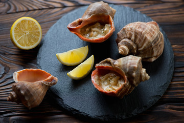 Stone slate plate with julienne served in rapana shells, closeup
