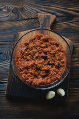 Glass bowl with bolognese sauce in a rustic wooden setting