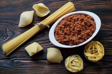Fototapeta na wymiar Freshly made bolognese sauce and variety of pasta, studio shot