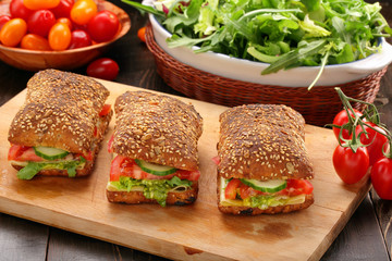 Vegetarian sandwich with pesto on wooden background