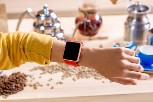 Female hand with smart watch with alternative coffee stuff on the background 