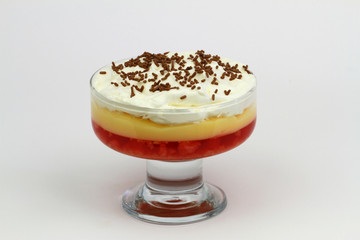 Traditional English strawberry trifle with fresh whipped cream on white background
