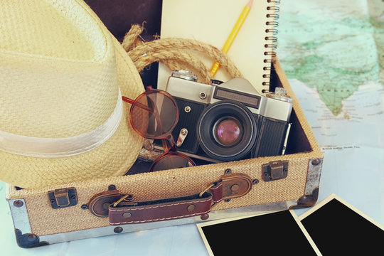 traveling concept. camera, cup of coffee, sunglasses, fedora hat and notebook. vintage style filtered. selective focus
