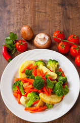 Mixed vegetables on a plate on wooden table