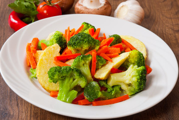 Mixed vegetables on a plate on wooden table