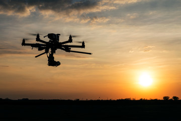 Professional drone flying in the sunset - obrazy, fototapety, plakaty