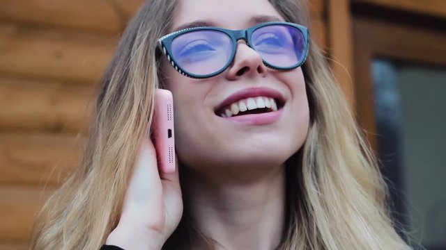 Beautiful and Cute Girl With Glasses, Talking on the Phone at the Hotel. the Girl Smiles. She is Very Happy and Friendly. Businesswoman.