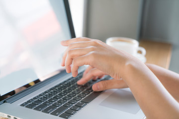 Closeup of business woman hand typing on laptop keyboard