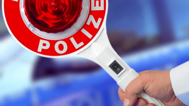 anhaltestab der Polizei vor einem Einsatzfahrzeug