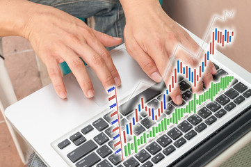 Hand typing on modern laptop notebook computer with future graph