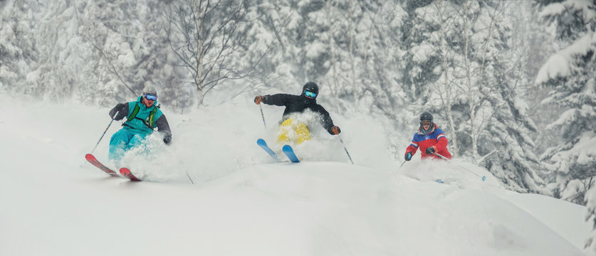 Three Skiing Friends Moving Downhill