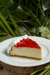 piece of cake decorated with strawberry jam and whipped cream, on a white plate