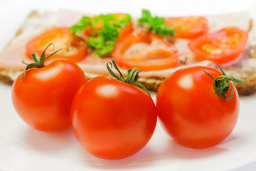 Fresh light breakfast made of brown bread with ham and tomatoes