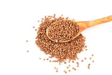 Uncooked buckwheat on wooden spoon