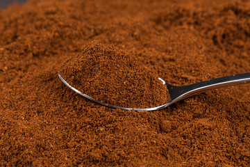 ground coffee and a metal spoon