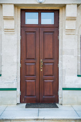Brown wooden door on brick wall