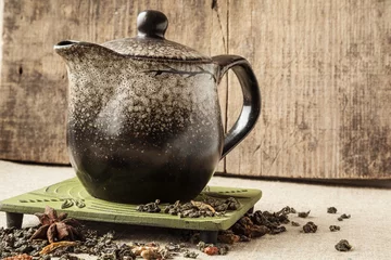 Foto op Aluminium  ceramic teapot  plate leafs and color cardamom on the table © Ivan Melnikov