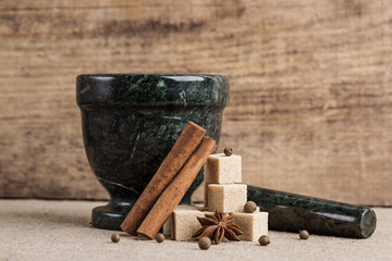 granite mortar sugar star anise allspice cinnamon on the  table
