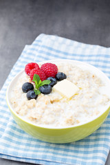 Oatmeal porridge in bowl with berries raspberries and blackberri