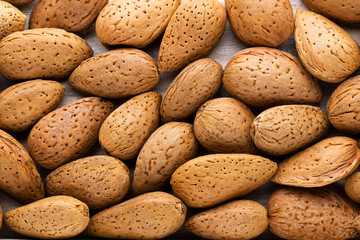 Group of almond nuts with leaves.Wooden background.