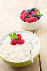 Oatmeal porridge in bowl with berries raspberries and blackberri