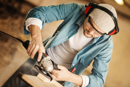 Carpenter working with power sander