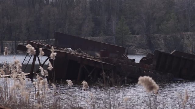 Graveyard of ships on the river.  Many rusty barges and boats in water. Chernobyl zone of alienation