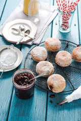 Filling homemade donuts with strawberry jam