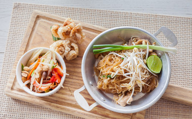 Thai food, fried noodles Thai style with papaya salad and pork c