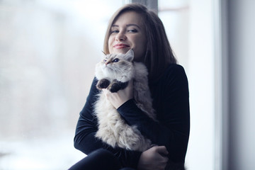 Girl with a cat in the window